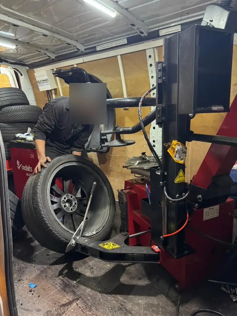 Technicien Fast Depann démontant un pneu sur la machine à pneus du camion atelier – Changement de pneus Fast Depann