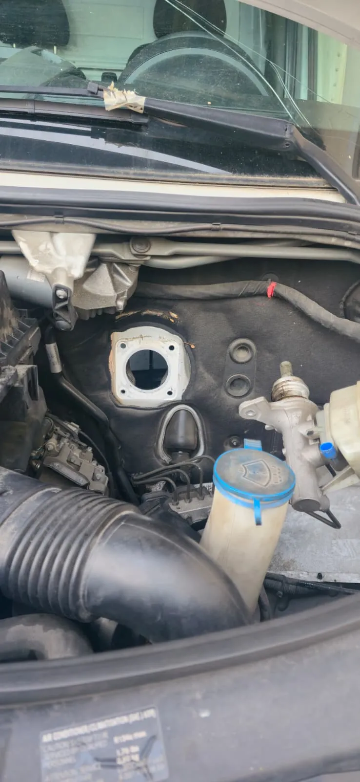 Compartiment moteur d’un Mercedes-Benz Sprinter après dépose du Mastervac : trou de passage dans le tablier, maître-cylindre et bocal de liquide de frein écartés
