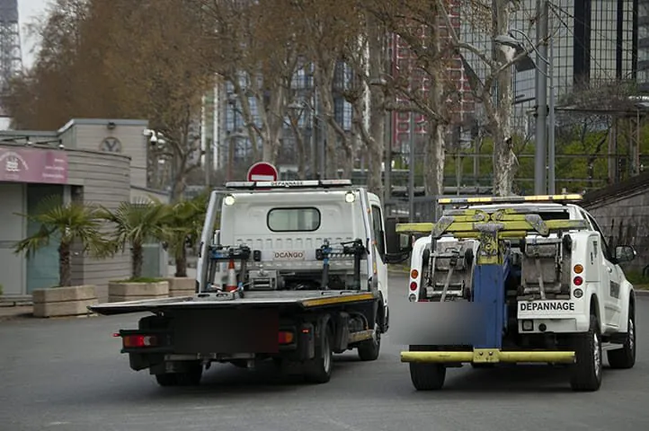 Deux dépanneuses vues de l’arrière dans une rue de Paris
