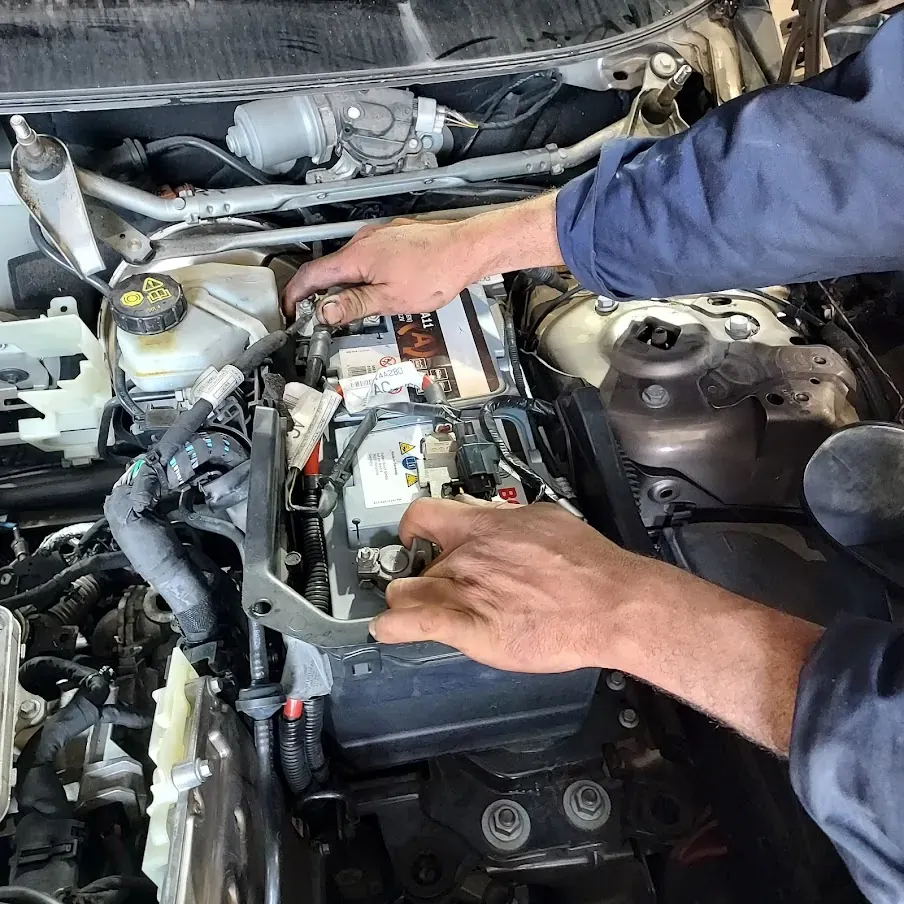 Dépanneur intervenant sur la batterie d’une voiture, capot ouvert (photo d’illustration – à Épernay (51200))