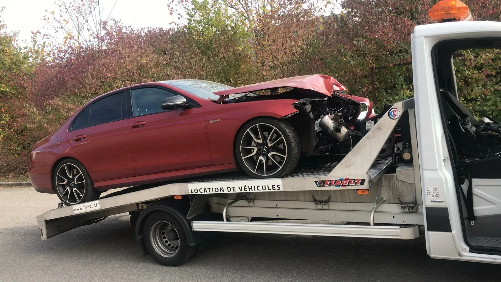 Berline rouge accidentée sanglée sur un plateau – Dépannage auto
