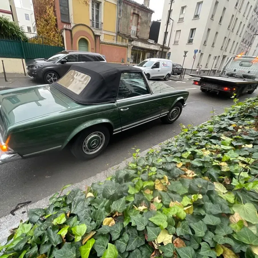 Mercedes 280 SL verte avec une dépanneuse à l’arrière-plan, à Beauchamp – dépannage auto