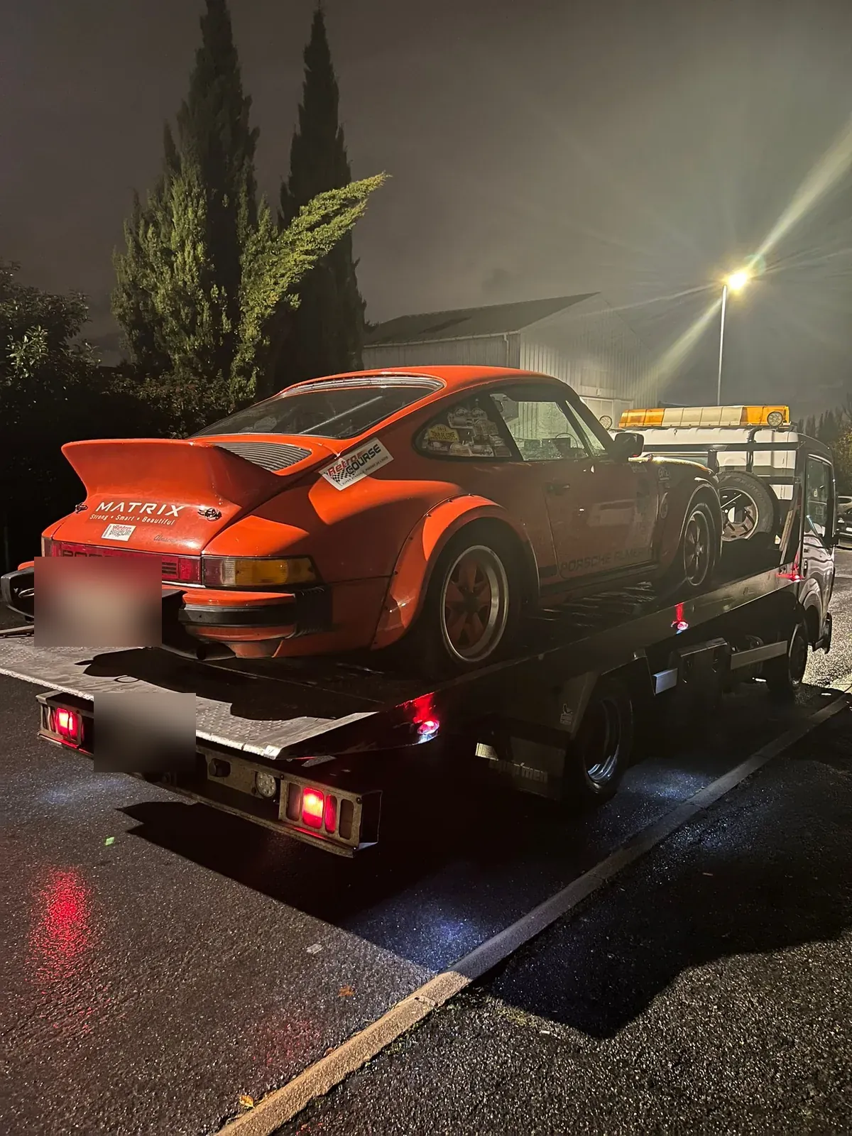 Porsche 911 orange chargée de nuit sur un plateau aux Loges-en-Josas – dans les Yvelines (78)