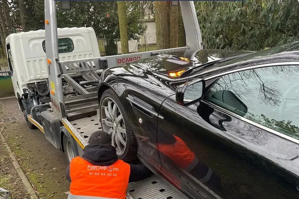 Dépanneur Fast Depann arrimant une berline noire sur un plateau à Osny – dans le Val-d’Oise (95)