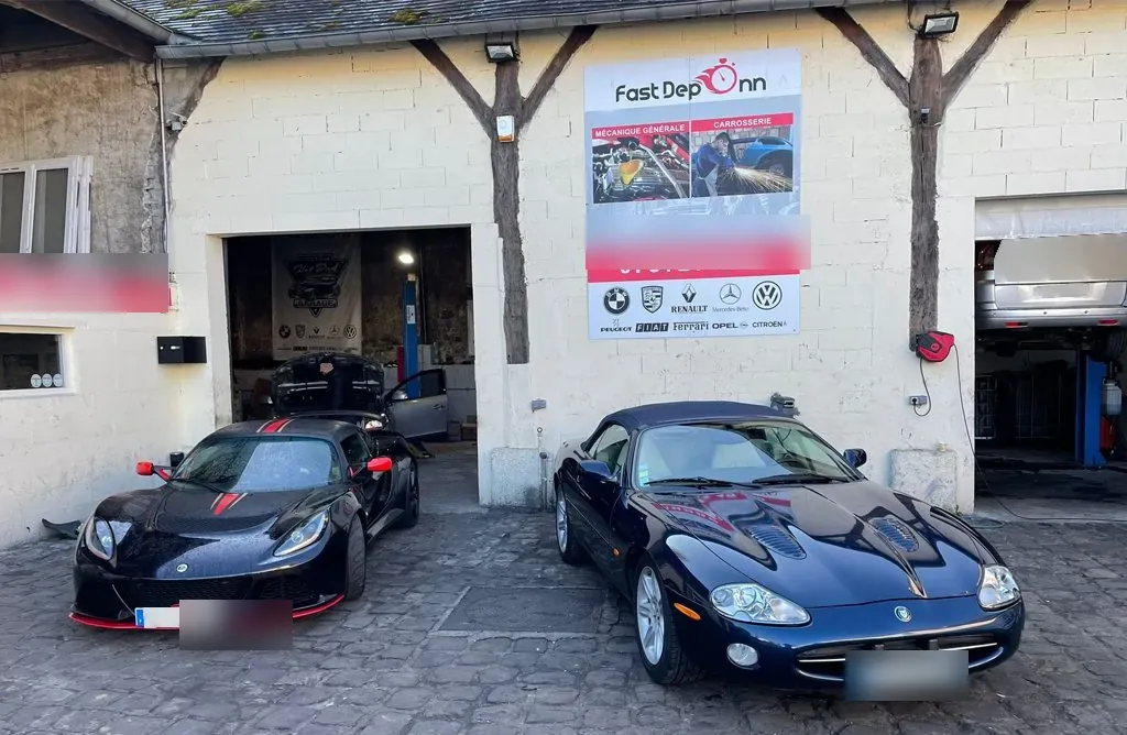 Atelier à l’enseigne Fast Depann avec une Lotus et une Jaguar garées devant – dépannage auto à Persan